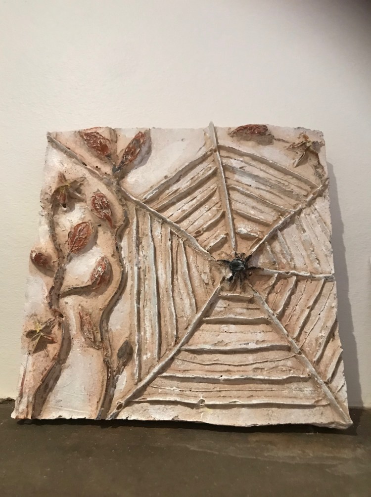 A porcelain tile sculpture showing a spider web and leaves by Ciorsdan Glass 